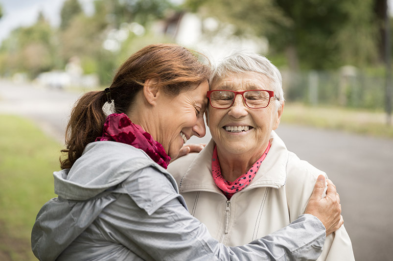 Two women smiling and hugging